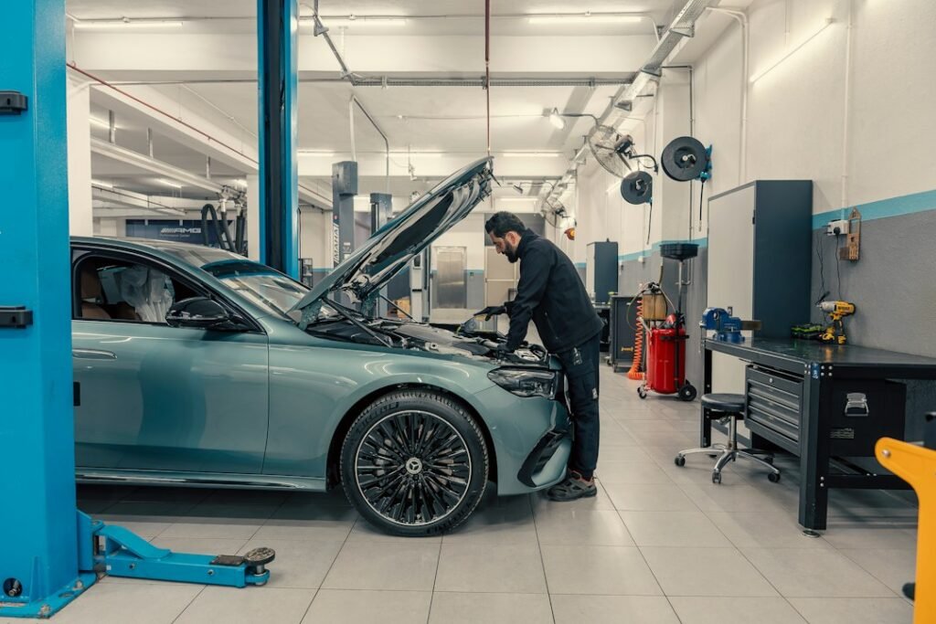Automotive service technician inspecting a vehicle in a workshop